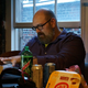 Mike Fahey of Kotaku, gesturing with an open hand toward an open Razer laptop in the old Gawker Media offices.